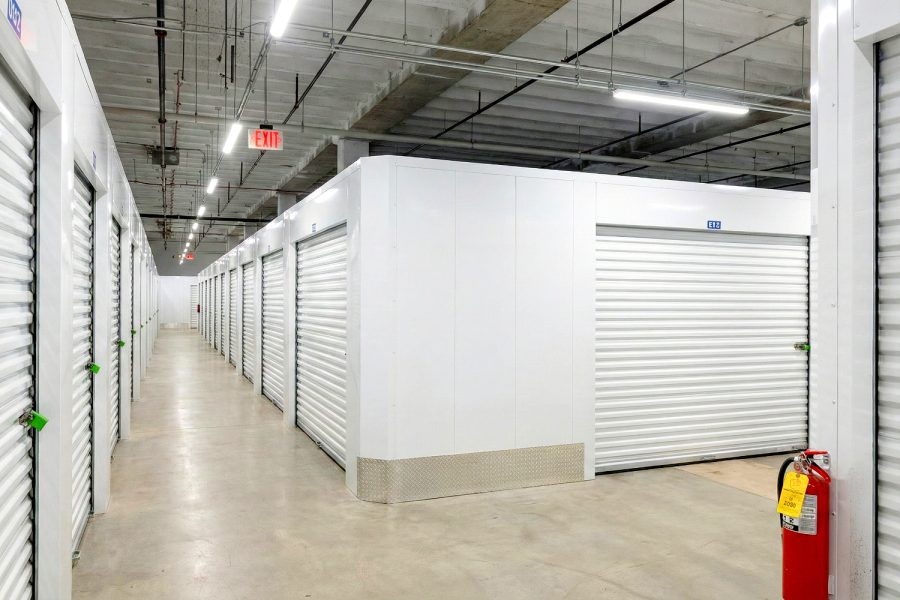 Indoor self storage Aurora IL hallway with roll-up doors, unit numbers, and fire extinguisher