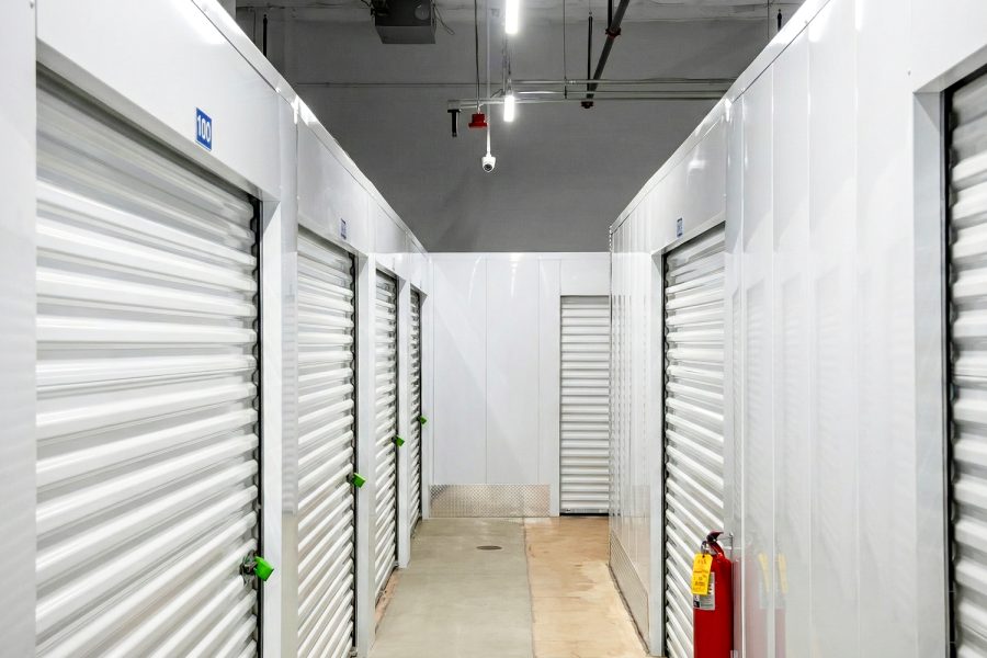 Indoor self storage Aurora IL hallway with roll-up storage unit doors, security camera